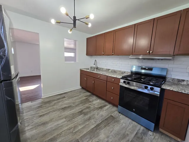 a kitchen with stainless steel appliances granite countertop a stove a sink and a refrigerator