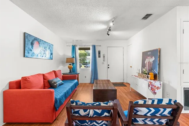 a living room with furniture and a view of kitchen