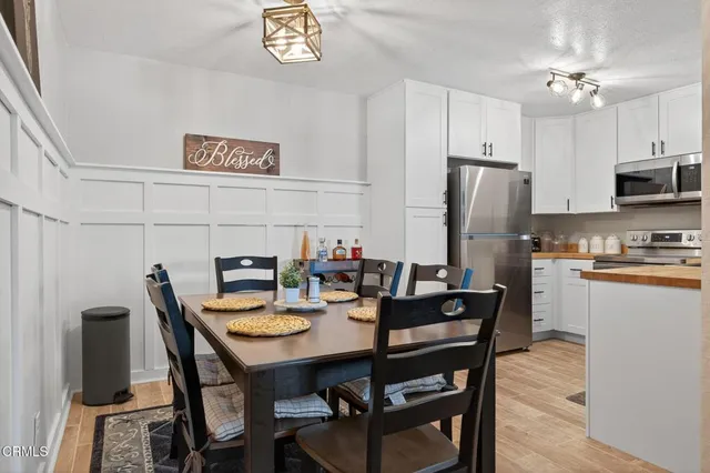 a view of a dining room with furniture and a refrigerator