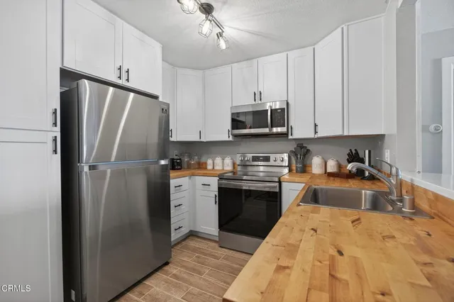 a kitchen with stainless steel appliances granite countertop a refrigerator stove microwave and sink