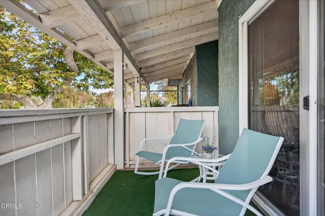 a view of a chair and table in backyard of the house