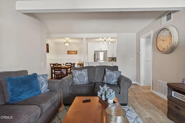 a living room with furniture a clock and a window