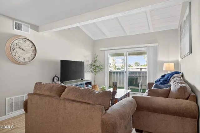 a living room with furniture a large window and a flat screen tv