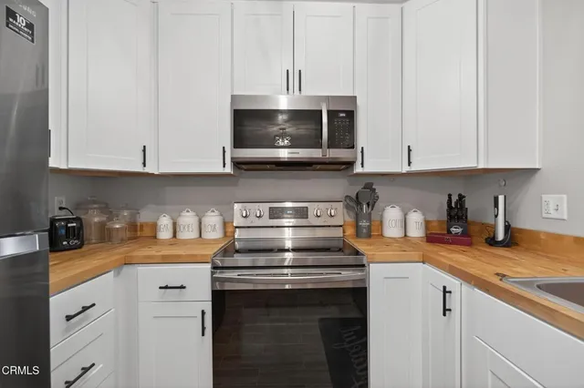 a kitchen with stainless steel appliances granite countertop a sink stove and cabinets