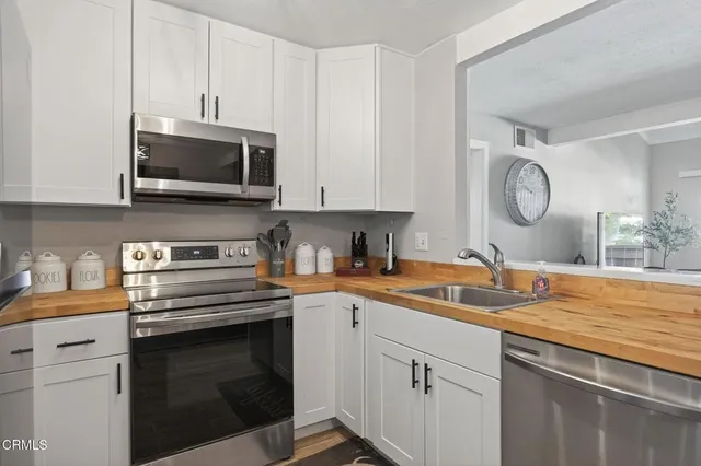 a kitchen with stainless steel appliances granite countertop a sink a stove and cabinets