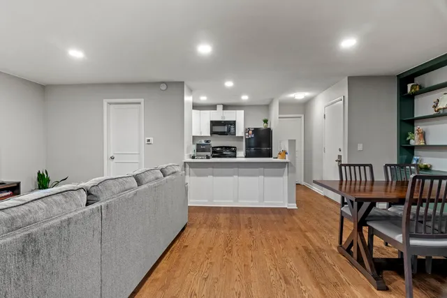 a large kitchen with stainless steel appliances kitchen island granite countertop a table chairs in it and a wooden floors