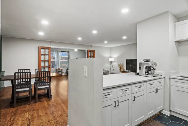 a kitchen with white cabinets and chairs