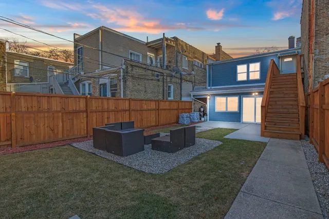 a view of a house with backyard and sitting area