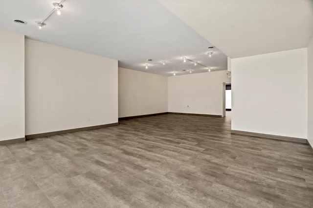 an empty room with wooden floor and white walls
