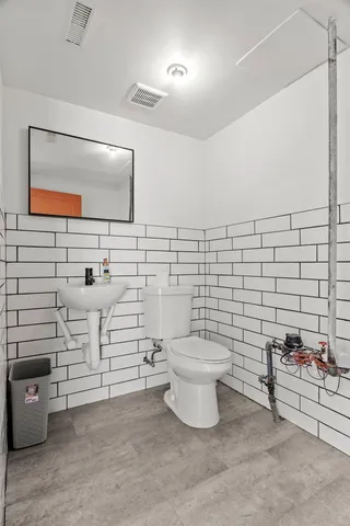 a bathroom with a toilet sink and mirror