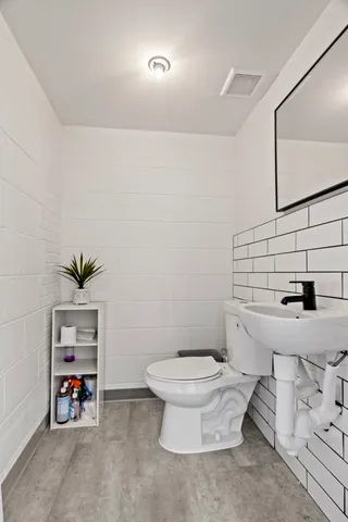 a bathroom with a sink a toilet and a mirror