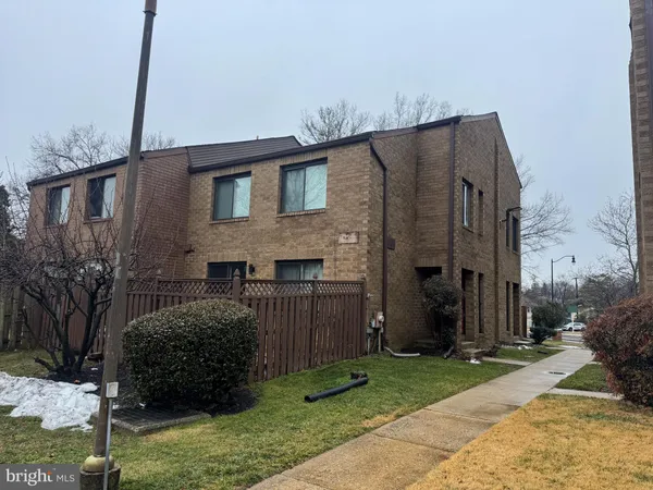 a brick house that has tree in front of it