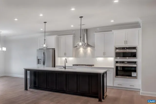 a kitchen with kitchen island a sink stainless steel appliances and cabinets