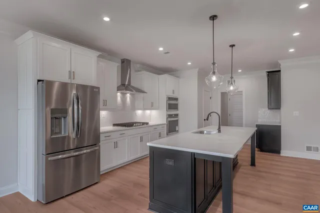 a kitchen with kitchen island a sink stainless steel appliances and cabinets