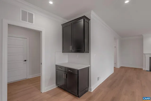 a view of an empty room with wooden floor and a cabinet