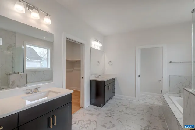 a spacious bathroom with a bathtub sink and mirror
