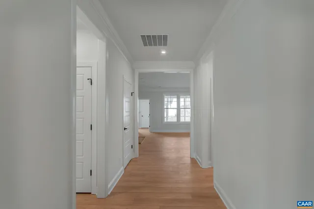a view of a hallway with wooden floor and closet