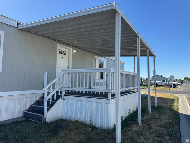 2491 Highway 89, Unit 315 Pleasant View, UT 84404 - Photo 2 of 34 Front exterior featuring light gray siding, a covered porch with white railing, and white trim accents