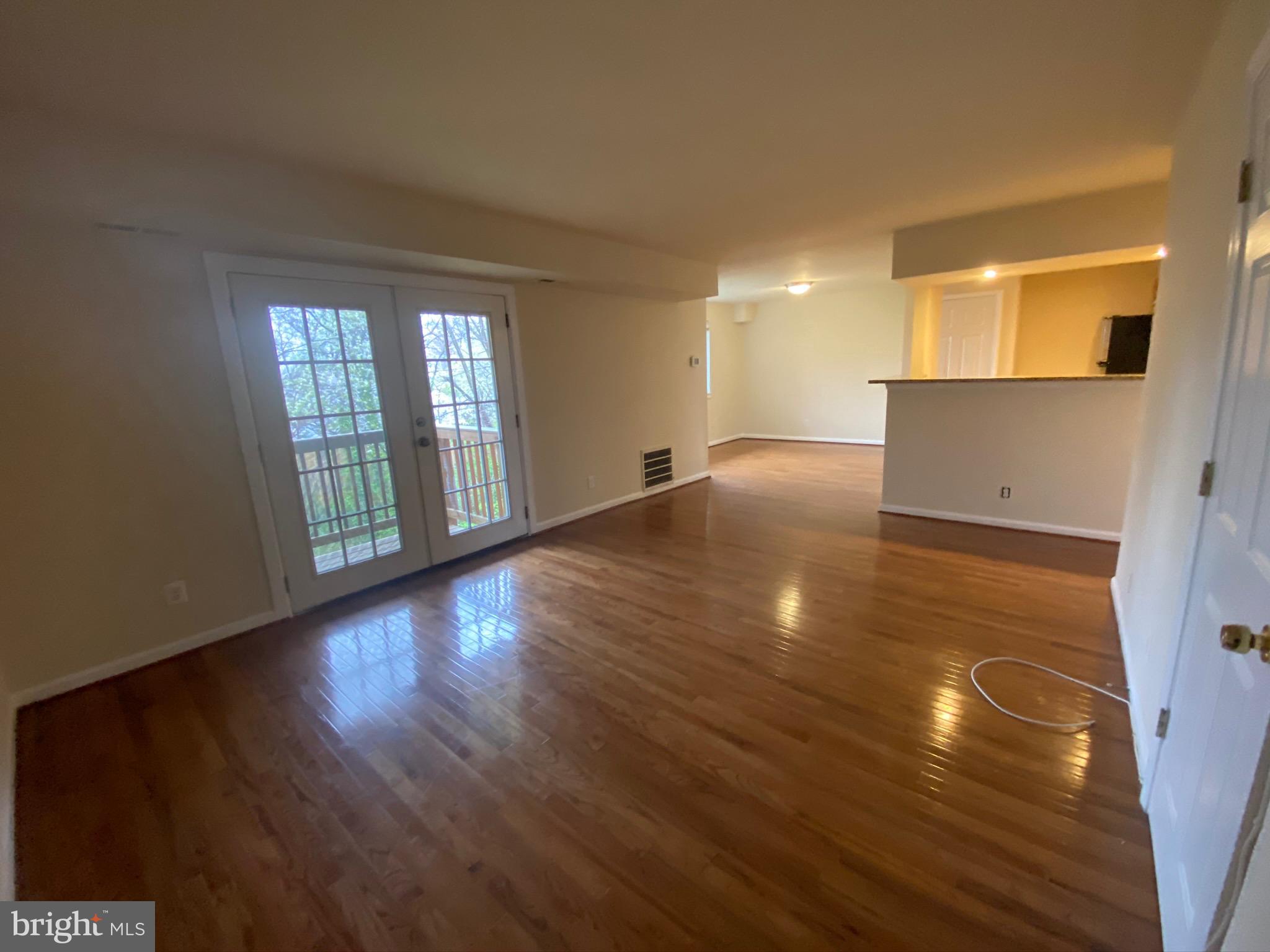 7514 Hawthorne Street, Unit 5 Landover, MD 20785 - Photo 2 of 16 a view of an empty room with wooden floor and a window