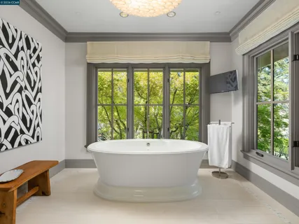 a white bath tub sitting in a bathroom next to a window