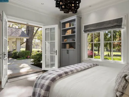 a bedroom with a bed and a large window with outer view