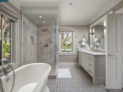 a bathroom with a tub a sink a mirror and a shower