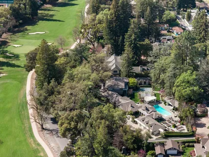 an aerial view of residential houses with outdoor space and trees