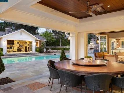 a dining room with furniture a rug and a floor to ceiling window