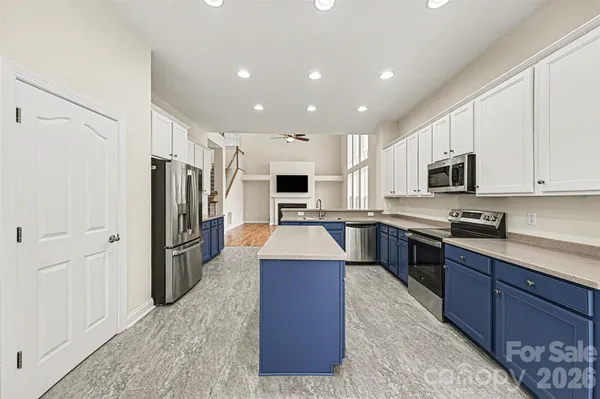 a large kitchen with stainless steel appliances kitchen island granite countertop a refrigerator stove top oven and sink