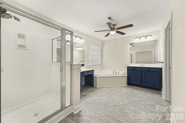 a large bathroom with a tub shower and sink
