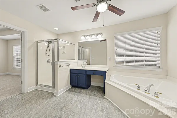 a spacious bathroom with a large tub shower and sink
