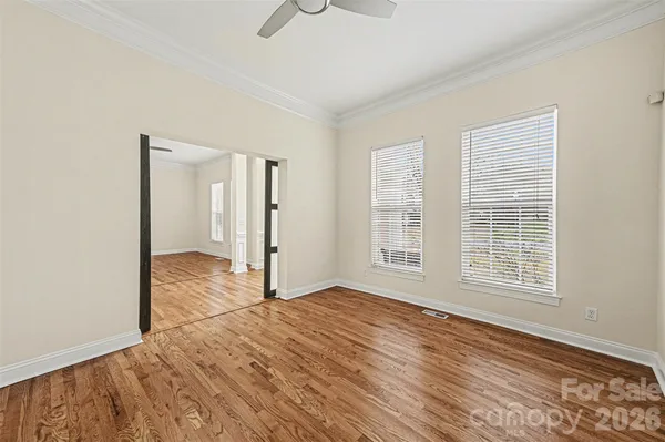 an empty room with wooden floor and windows