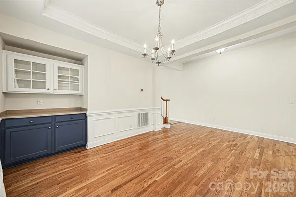 a big room with wooden floor and chandelier