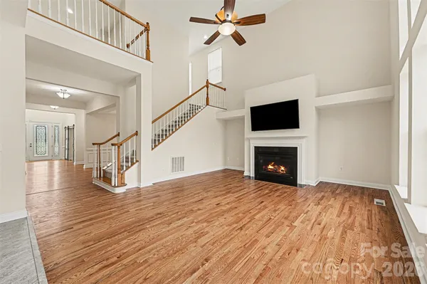 a view of empty room with wooden floor and fireplace
