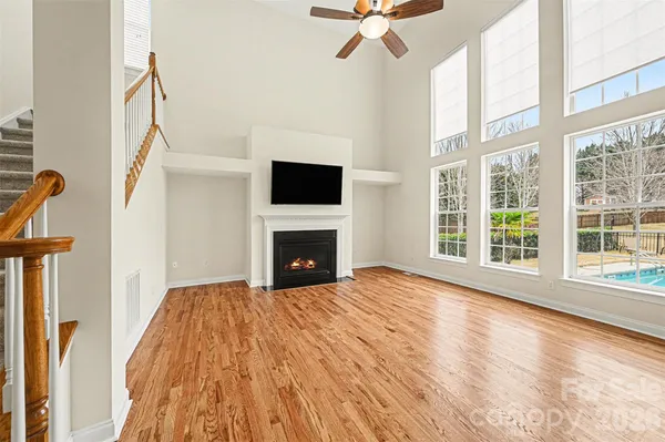 a view of empty room with fireplace and wooden floor