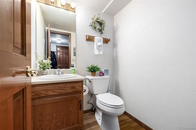 a bathroom with a granite countertop toilet sink and mirror