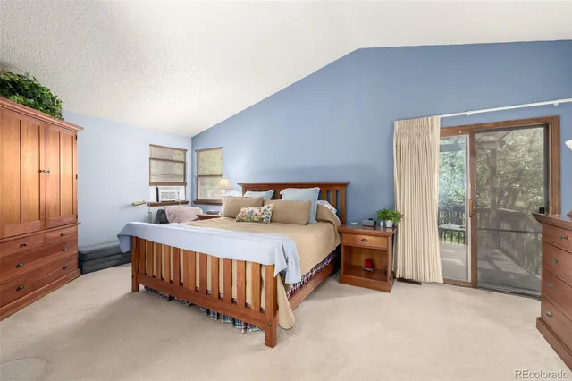 a bed sitting in a spacious bedroom next to a window