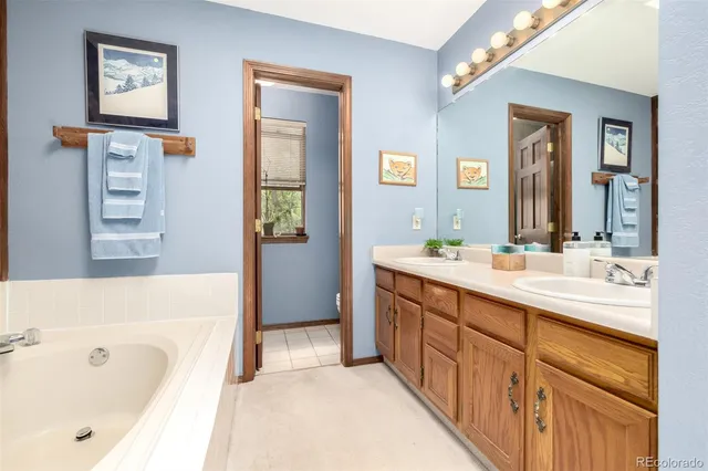 a spacious bathroom with a tub sink and mirror