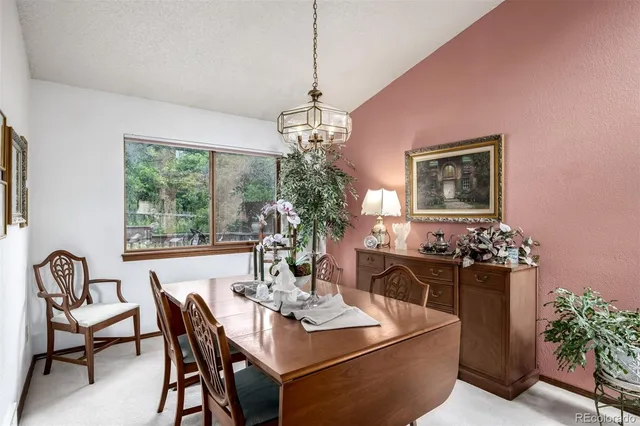 a dining room with furniture a chandelier and window