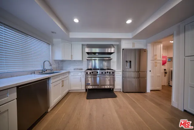 a kitchen with cabinets a sink and stainless steel appliances