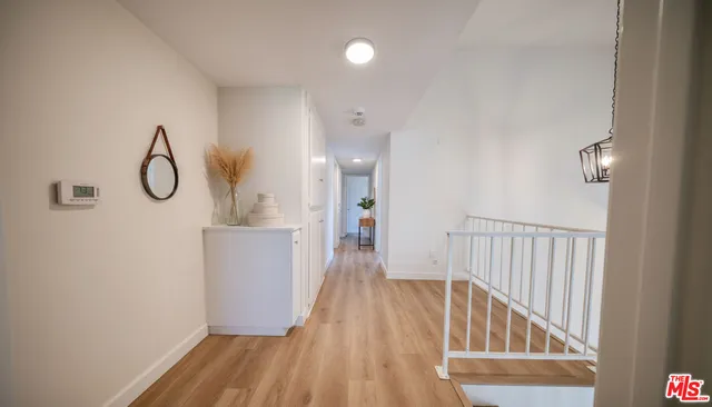 a view of entryway and hall with wooden floor