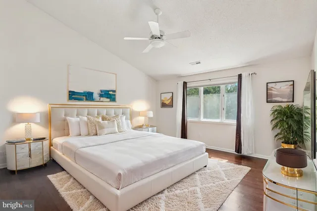 a bedroom with a large bed and a potted plant