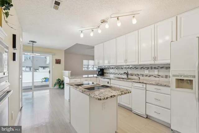 a kitchen with cabinets appliances a sink and a counter top space