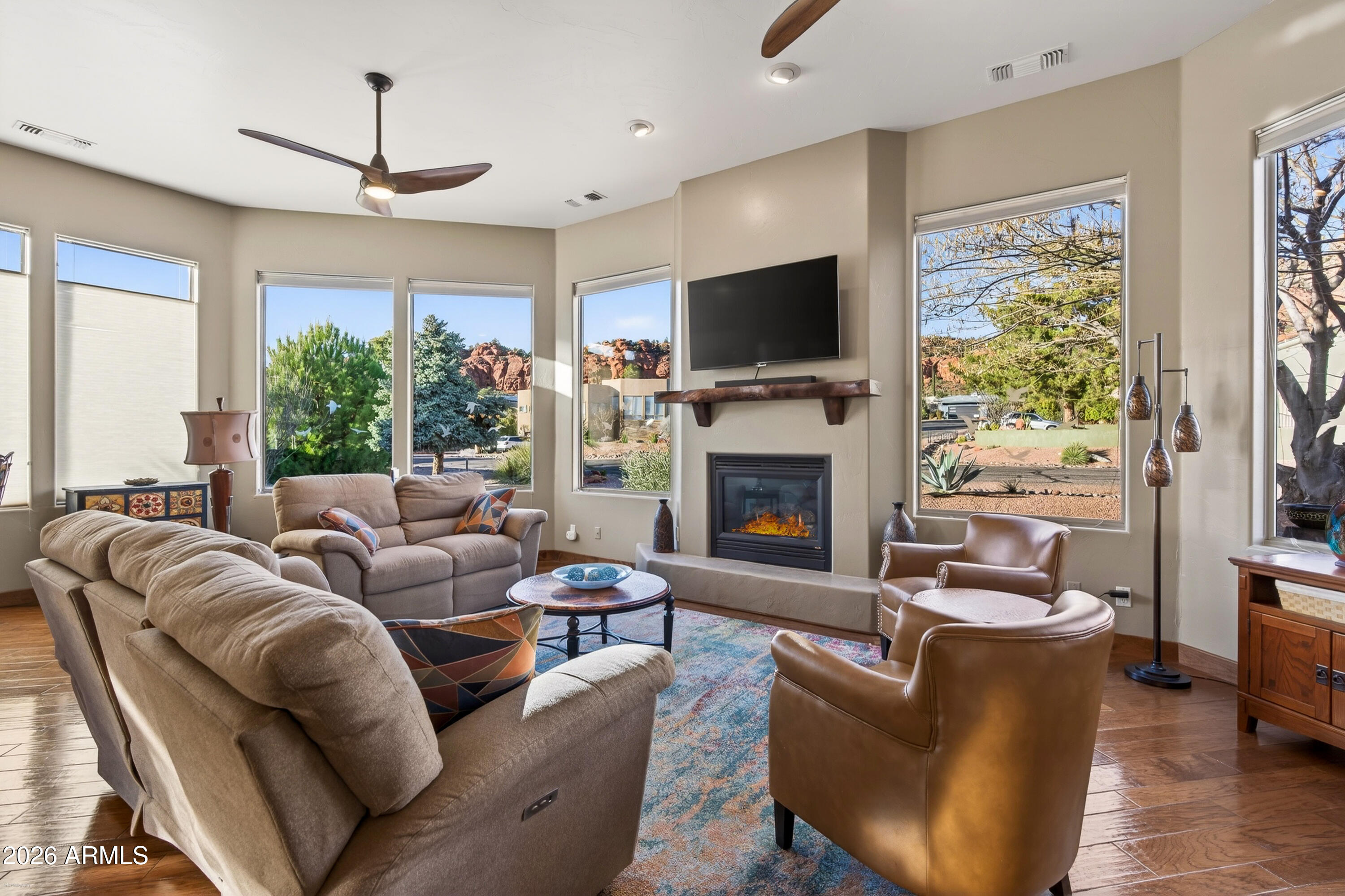 345 Merry Go Round Rock Road Sedona, AZ 86351 - Photo 6 of 43 a living room with furniture a flat screen tv and a fireplace