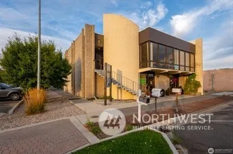 a view of a brick house with a large windows and a table and chairs