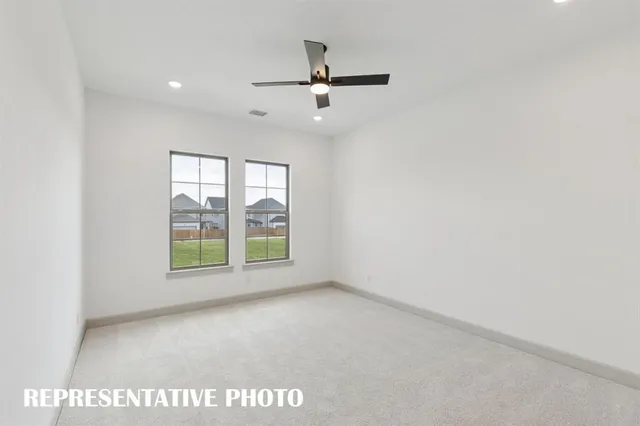 an empty room with windows and ceiling fan