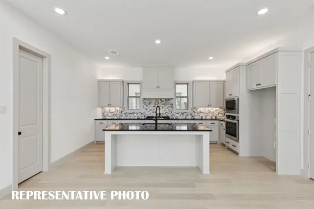 a kitchen with stainless steel appliances a sink and a refrigerator