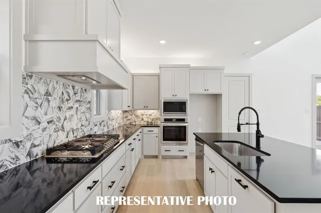 a kitchen with granite countertop a stove and a sink