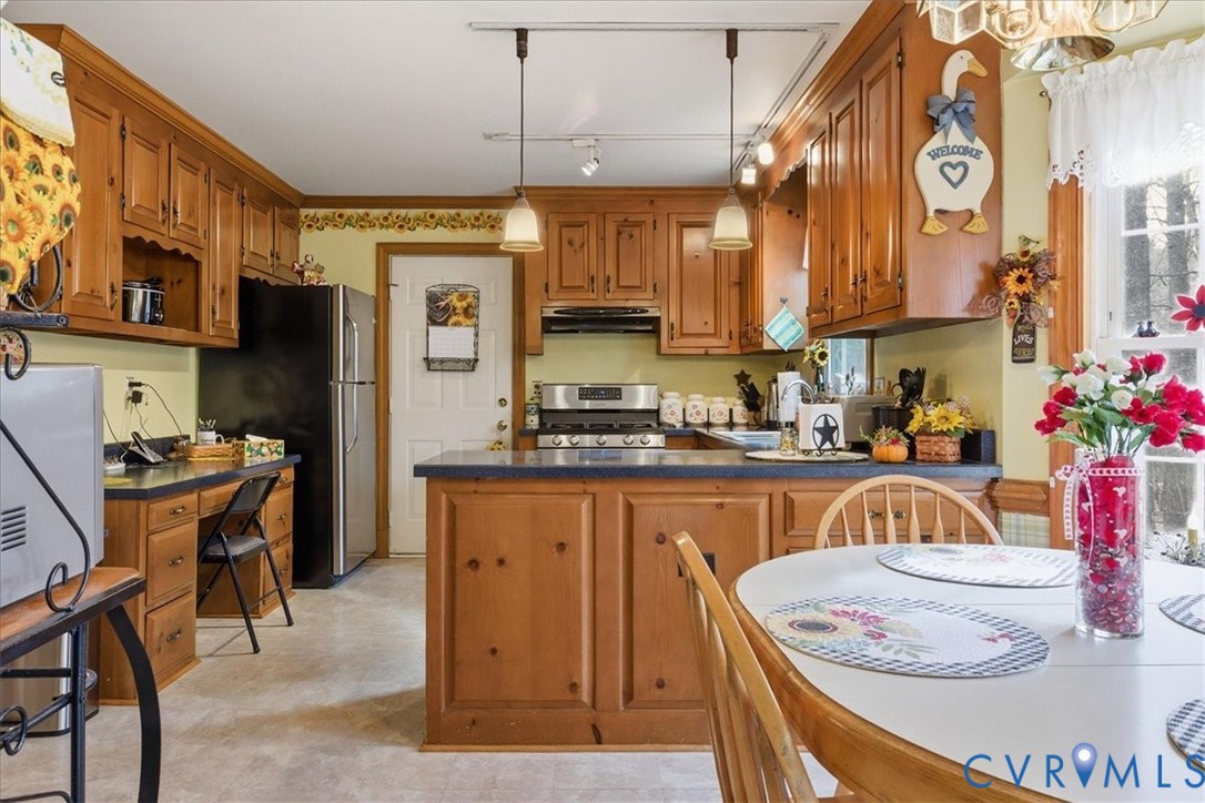 14110 Howlett Line Drive Colonial Heights, VA 23834 - Photo 19 of 44 a kitchen with stainless steel appliances granite countertop a refrigerator a sink dishwasher a stove and a dining table with wooden floor
