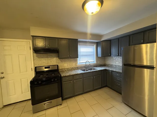 a kitchen with stainless steel appliances granite countertop a refrigerator and a sink
